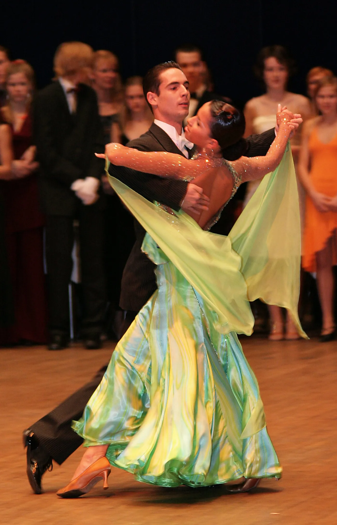 Pareja bailando una exhibición de baile de salón con vestido elegante