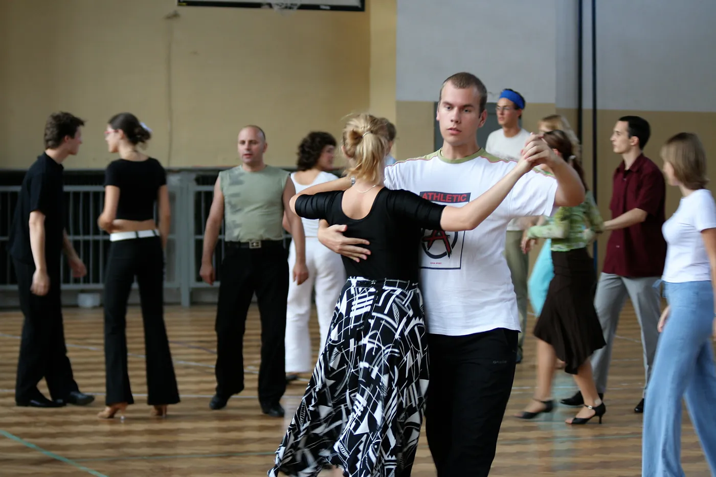 Grupo de personas practicando pasos de baile de salón en una clase